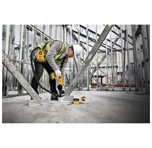 Ein Bauarbeiter verwendet einen Bolzensetzer in einem Rohbau.