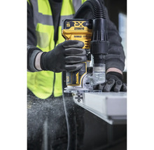 Eine Person bedient eine DeWalt Oberfräse mit Staubabsaugung während der Arbeit.