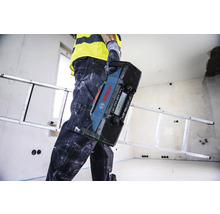 Artisan portant une radio de chantier Bosch dans une pièce avec une échelle