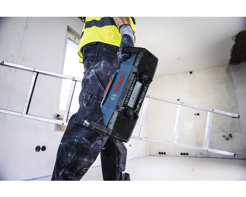 Artisan portant une radio de chantier Bosch dans une pièce avec une échelle