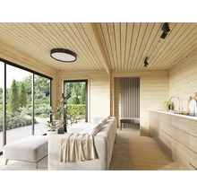 Salon lumineux avec lambris, canapé, cuisine et grandes fenêtres donnant sur le jardin.