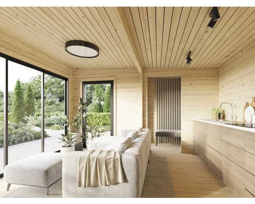 Salon lumineux avec lambris, canapé, cuisine et grandes fenêtres donnant sur le jardin.