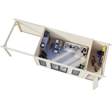 Vue intérieure d'une maison de jardin avec bureau, coin salon et espace de stockage.