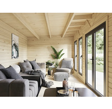 Intérieur d'une maison en bois avec fenêtres, sièges et éléments décoratifs.