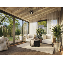 Heller Wintergarten mit Sitzbereich, bestehend aus Sofas, Sessel und Pflanzen