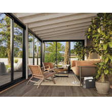 Heller Wintergarten mit Terrassendielen, Sitzmöbeln, Sofa und großen Fensterfronten