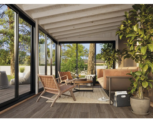 Überdachte Terrasse mit Sitzmöbeln, Teppich und grossen Glasfenstern