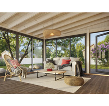 Helle Veranda mit Sofa, Sessel, Tisch und Blick in den Garten