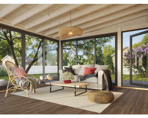 Wohnzimmer mit Sofa, Sessel, Tisch und Ausblick in den Garten