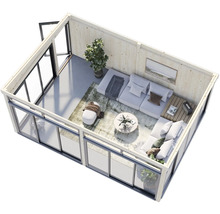 Vue d'une maison de jardin moderne avec coin salon, équipée d'un canapé, d'une table et de décorations