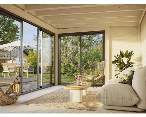 Salon lumineux avec canapé, fauteuil, tapis et vue à travers de grandes fenêtres sur le mobilier de jardin à l'extérieur.