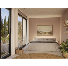 Helles Schlafzimmer mit Doppelbett, Gemälde und großen Fenstern mit Zugang zum Garten