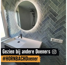 Badezimmer mit Waschbecken, Spiegel und Wandfliesen im Fischgrätmuster