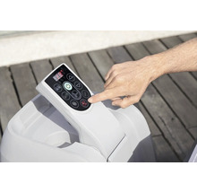 Panneau de commande d'un jacuzzi avec une main appuyant sur un bouton