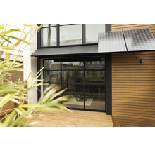 Außenansicht eines Hauses mit Solarpanelen und Glasgaragentor