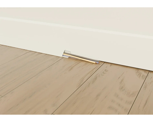 Plinthe avec goulotte de câbles et câbles posés à l'intérieur devant un plancher en bois