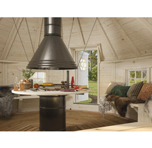 Intérieur d'un chalet de grillades avec table de cuisson centrale et coin repas.