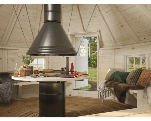 Intérieur d'un chalet de grillades avec table de cuisson centrale et coin repas.