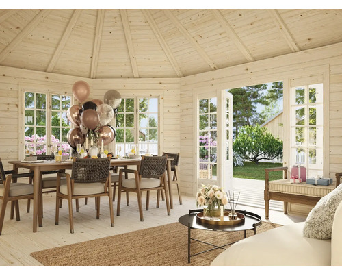 Maison en bois clair avec table à manger, chaises, décoration et fenêtres ouvertes sur le jardin.