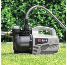 Pompe de jardin sur pelouse avec tuyaux connectés