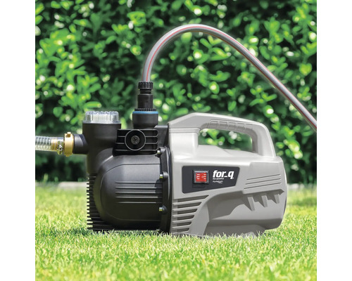 Pompe de jardin sur pelouse avec tuyaux connectés