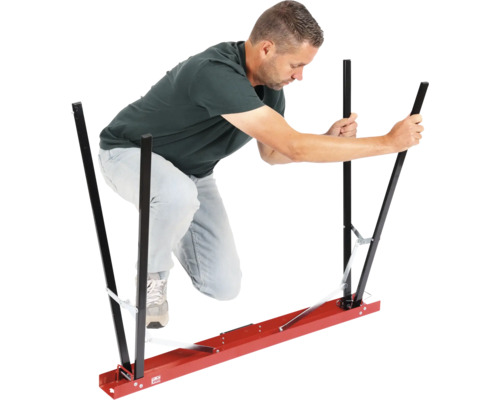 Mann bedient eine Tragehilfe für Gipsplatten