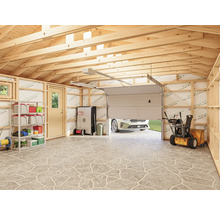 Garage lumineuse avec ossature en bois, étagères, armoires de rangement, souffleuse à neige et porte de garage partiellement ouverte