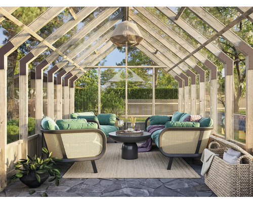 Helles Gewächshaus mit Sitzgruppe, Tisch und Dekoration für den Aussenbereich.