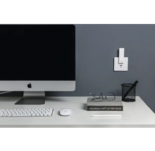 Espace de travail avec ordinateur, clavier, souris et station de charge au mur