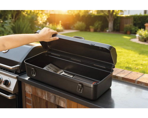 Geöffnete Grillbesteckkiste mit Grillwender neben Grill im Garten.