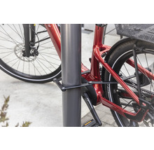 Vélo avec antivol pliant fixé à un poteau