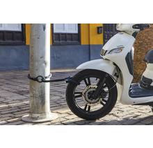 Scooter blanc avec antivol à câble fixé à un poteau