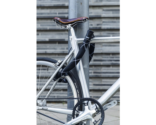 Vélo sécurisé à un lampadaire avec un antivol à chaîne ABUS