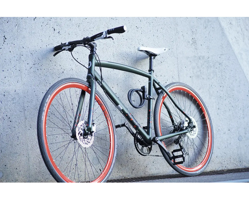 Vélo de trekking pour hommes contre un mur de béton