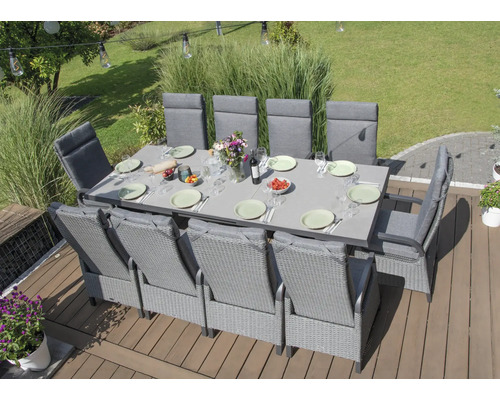 Gartenszene mit großem Esstisch und mehreren Stühlen auf einer Terrasse