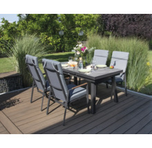 Scène de jardin avec table à manger et chaises sur une terrasse.