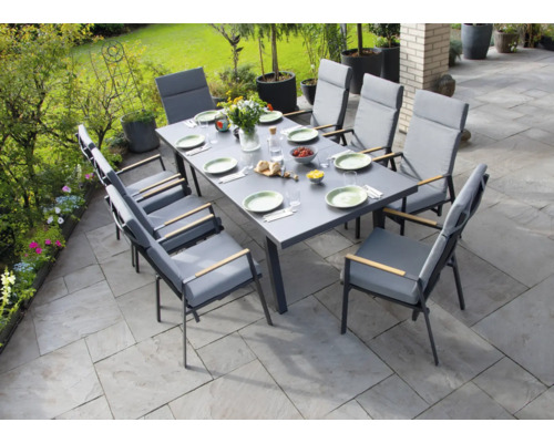 Groupe de salle à manger avec huit chaises sur une terrasse avec décoration de jardin