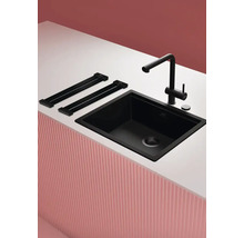 Schwarze Küchenspüle mit Armatur und Ablage auf einer Arbeitsplatte