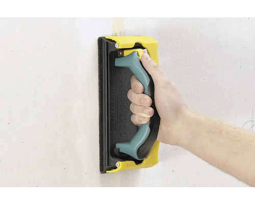 Main avec hérisson abrasif pour poncer un mur