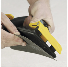 Ponceuse manuelle avec papier abrasif en cours d'utilisation