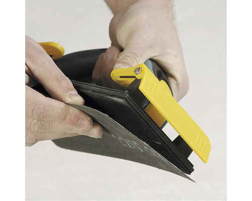 Ponceuse manuelle avec papier abrasif en cours d'utilisation