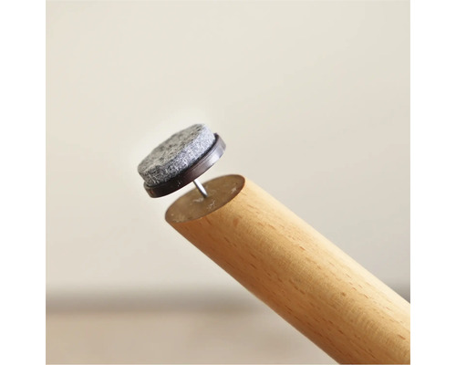 Filzgleiter mit Nagel an einem Möbelbein aus Holz