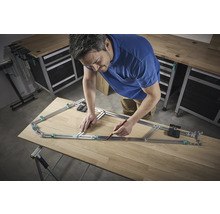 Ein Mann benutzt eine Konturenlehre, um eine Form auf ein Holzbrett zu übertragen.