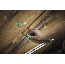 Montage von Montagewinkeln mit Schrauben und Unterlegscheiben an einer Metallschiene auf Holzuntergrund