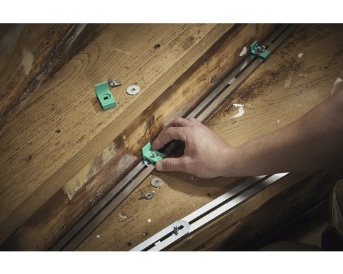 Montage von Montagewinkeln mit Schrauben und Unterlegscheiben an einer Metallschiene auf Holzuntergrund