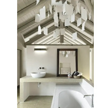 Salle de bains lumineuse avec toit mansardé, lavabo, miroir et éclairage décoratif