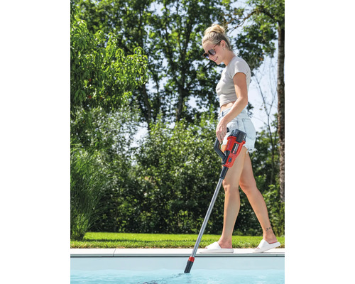 Une femme nettoie une piscine avec un aspirateur de piscine à manche.