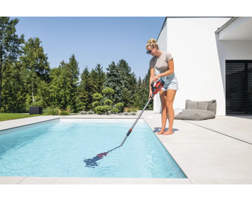 Femme nettoie piscine avec aspirateur de piscine