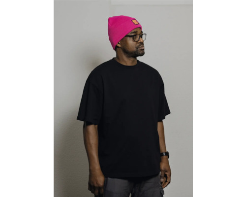 Mann mit Brille, schwarzem T-Shirt und pinkfarbener Mütze