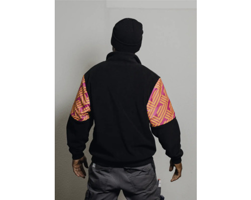 Homme vu de dos avec bonnet, veste polaire à motifs sur les manches et pantalon de travail